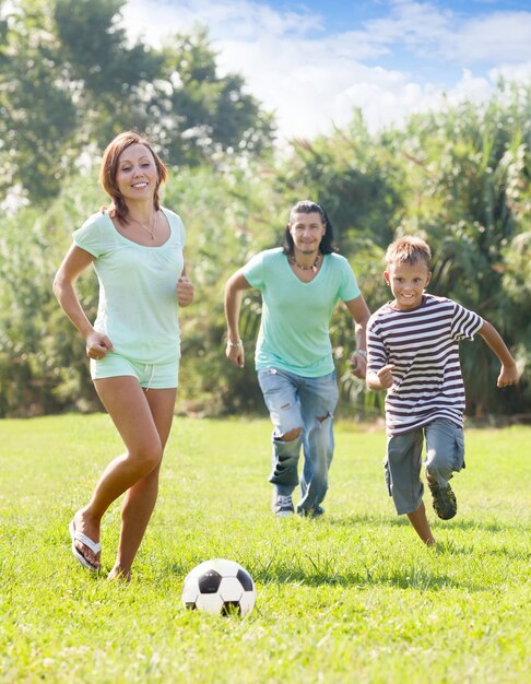 родители с сыном подростка, играя с футбольным мячом