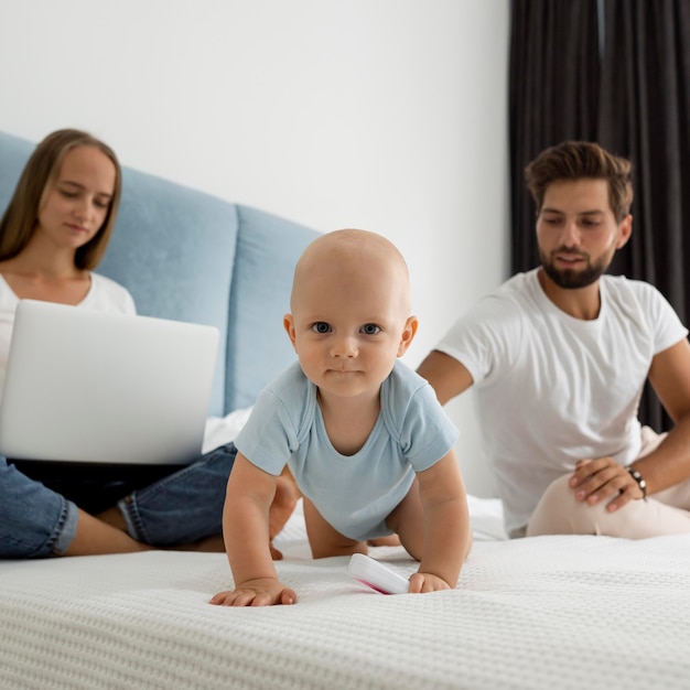 Free photo parents working on laptop from home during quarantine with child