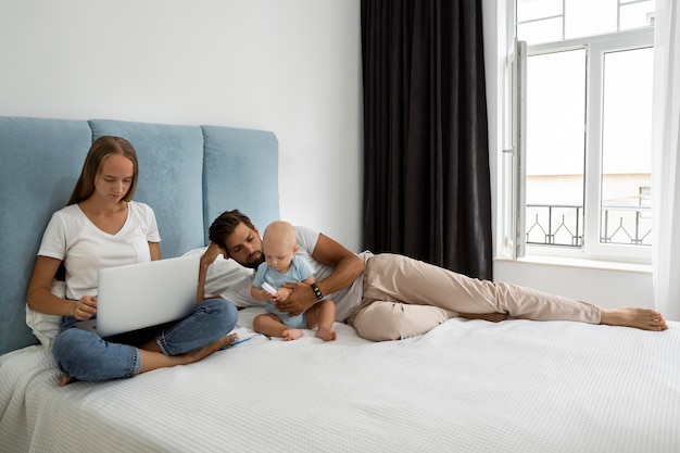 Parents working on laptop from home during quarantine with child