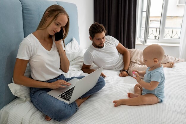 Parents working on laptop from home during quarantine with child