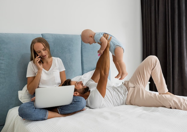 Parents working on laptop from home during quarantine with child