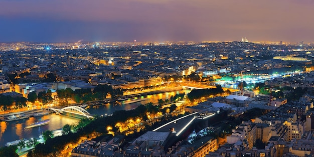 Paris city skyline rooftop view with River Seine at night, France.