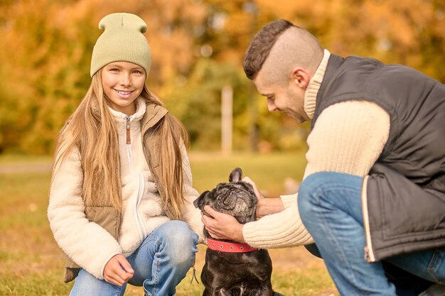 In the park. A family spending time together in the park with their dog