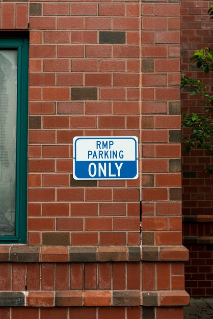 Parking sign on brick wall front view