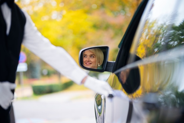 無料写真 女性が彼女の車を駐車するのを助ける駐車係員