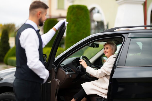 Parcheggiatore che aiuta la donna a parcheggiare la sua auto