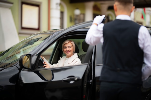 Parking valet helping woman park her car