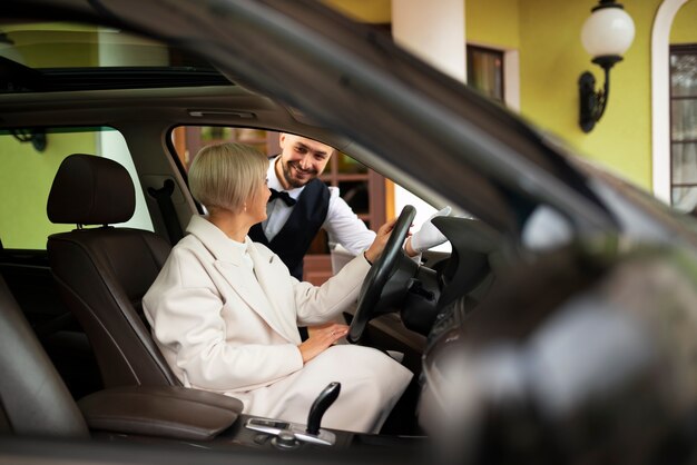 女性が彼女の車を駐車するのを助ける駐車係員