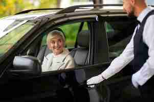 Foto gratuita parcheggiatore al suo lavoro con veicolo e donna