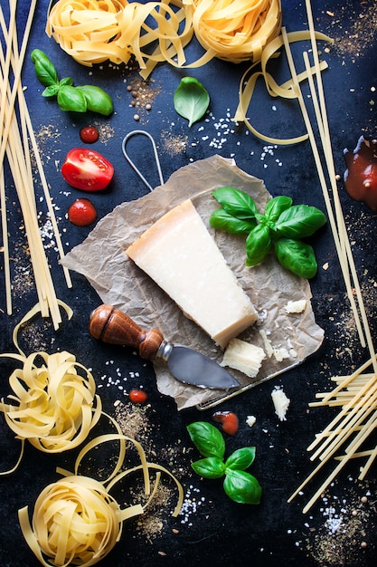 Parmesan pasta recipe with a piece of cheese and raw pasta and other ingredients