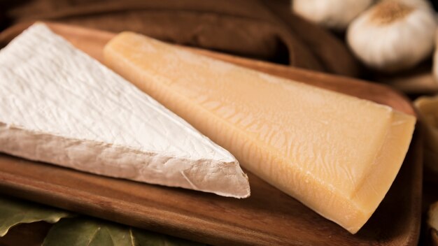 Parmesan and white cheese on wooden tray