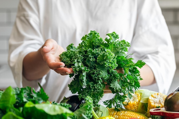 Parsley and kale closeup in the hands of a woman in the kitchen