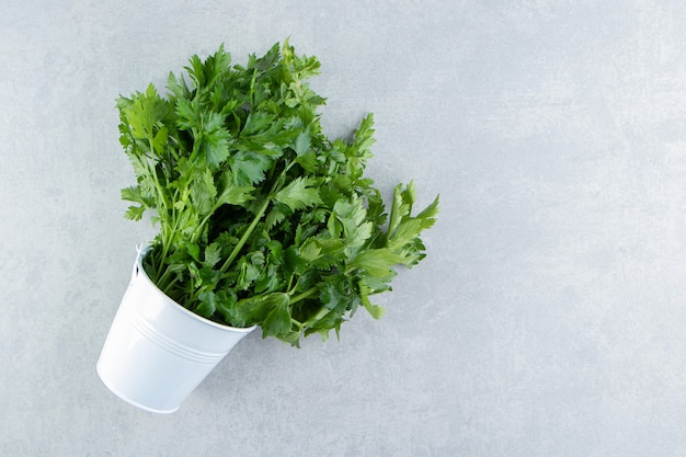 Free photo parsley in the white bucket , on the marble.