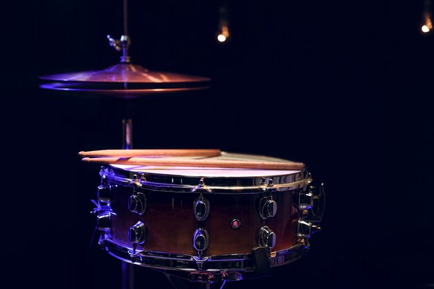 Part of a drum kit in the dark with beautiful lighting. Concert and performance concept.