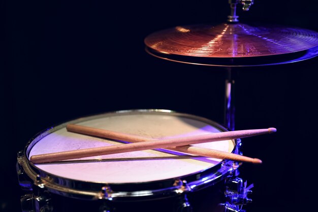 Part of a drum kit in the dark with beautiful lighting. Concert and performance concept.