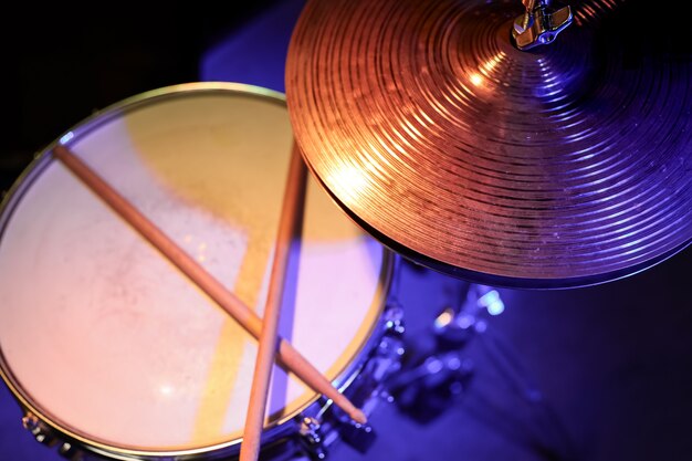 Part of a drum kit in the dark with beautiful lighting. Concert and performance concept.