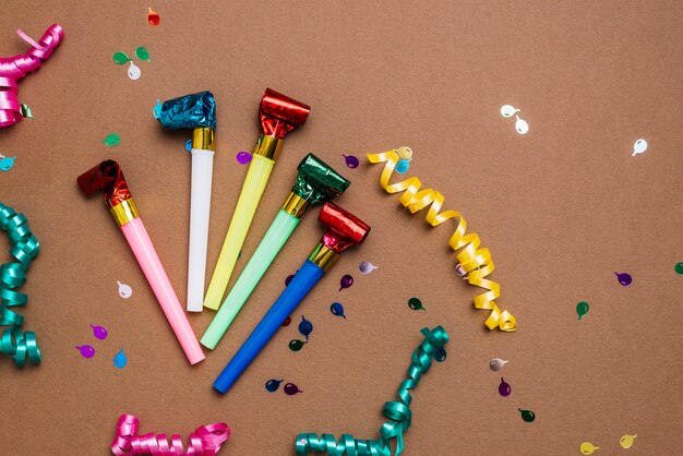 Party blowers; streamers and confetti on brown background