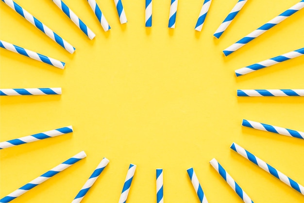 Free photo party drinking straws arranged into a circle on yellow background