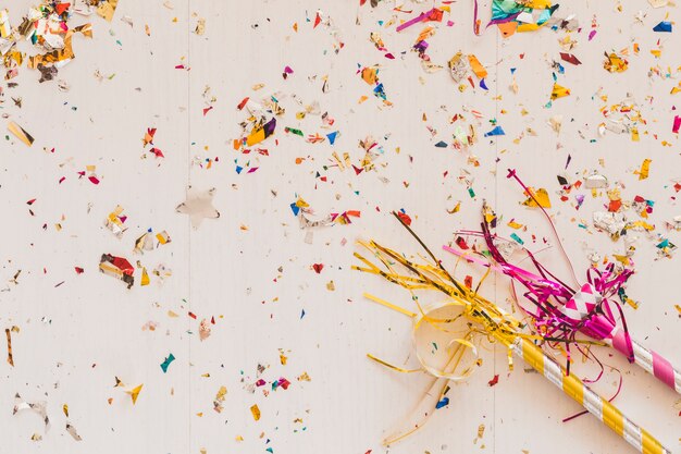 Party horns on table in confetti