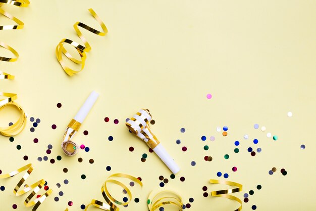 Party whistles and confetti with copy space