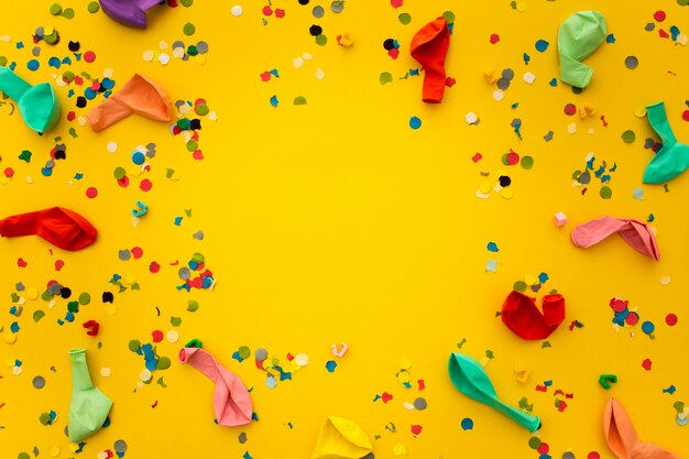 Party with confetti remnants and colorful balloons on yellow