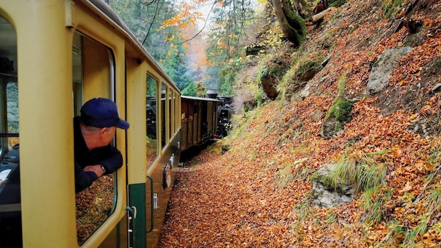 Foto gratuita il passeggero si sporgeva dal finestrino del treno a vapore mocanita, romania