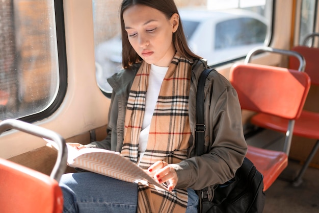 Foto gratuita passeggero che legge e viaggia in tram