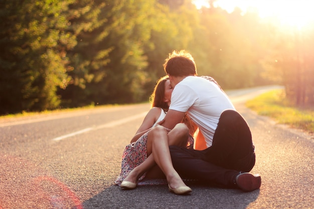 Passionate teenagers sitting on asphalt