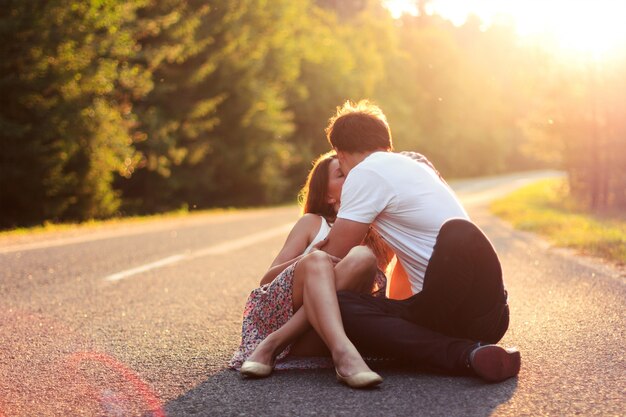 Passionate teenagers sitting on asphalt