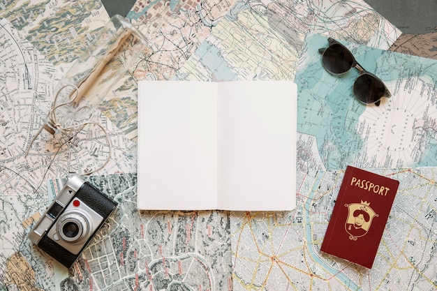 Foto gratuita passaporto con macchina fotografica e blocco note su mappe