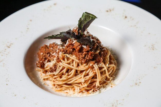 Pasta bolognese meat basil parmesan side view