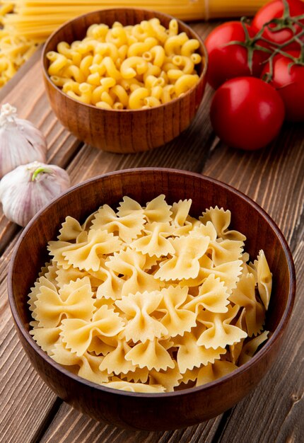 Pasta farfale in the wooden bowl tomato garlic side view