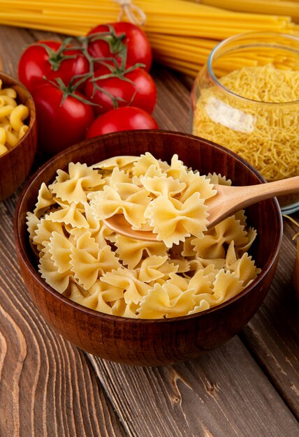 Pasta farfale in the wooden bowl tomato garlic side view