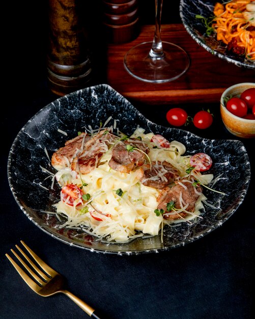 Pasta fettuccine with meat and tomato side view