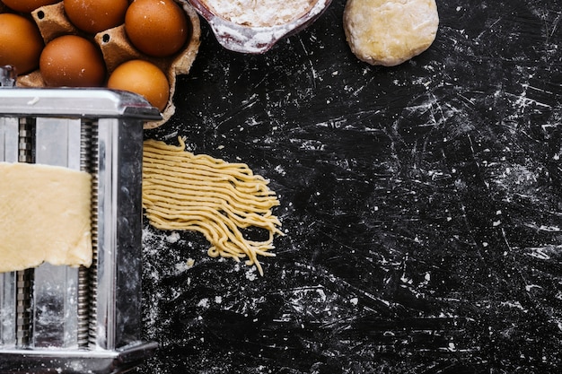 Free photo pasta going through machine near eggs