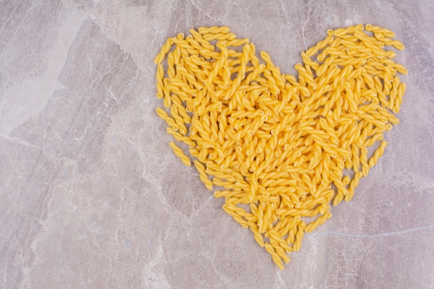 Pasta a forma di cuore sullo spazio in marmo.