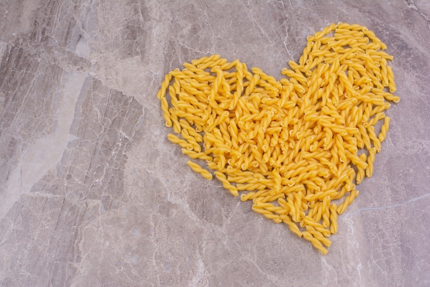 Pasta on a marble surface in heart shape