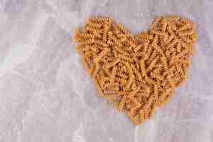 Foto gratuita pasta su una superficie di marmo a forma di cuore