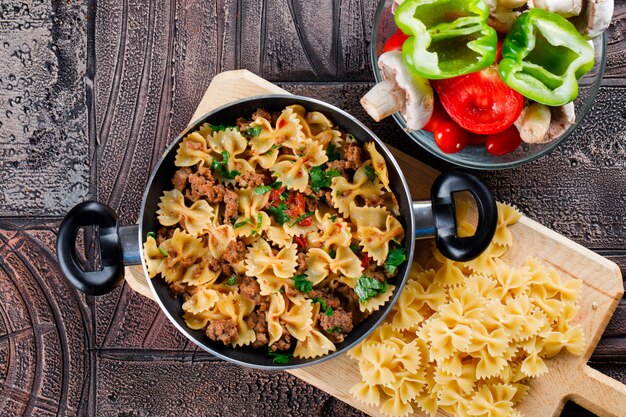 Pasta meal in pan with mushroom, pepper, tomato, raw pasta