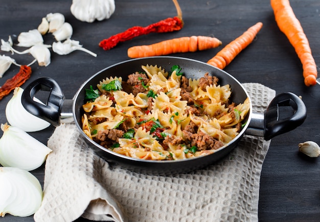 Free photo pasta meal in a pan with onion, garlic, carrots, peppers