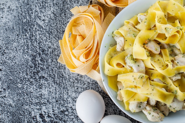 Pasta meal in a plate with eggs, raw pasta