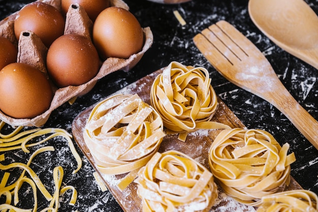 Pasta near eggs and utensils