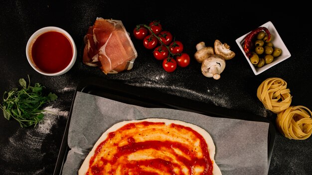 Pasta and pizza ingredients near dough