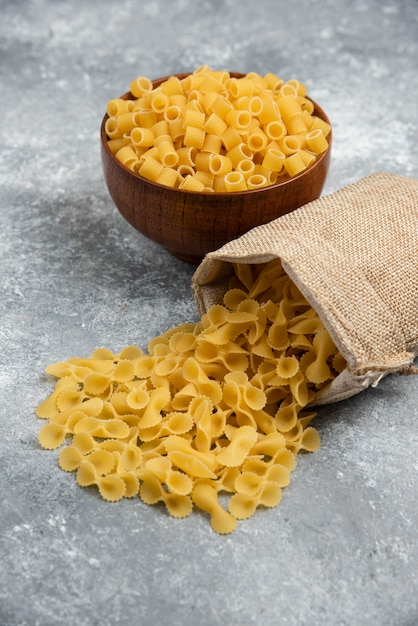 Pasta in un cestino rustico e in una ciotola di legno.