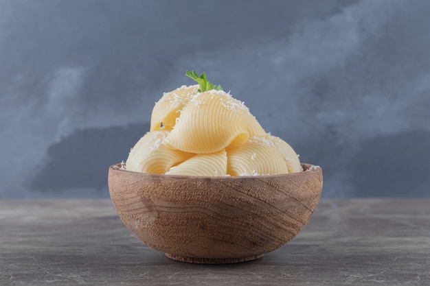 Pasta in a small bowl , on the marble surface.