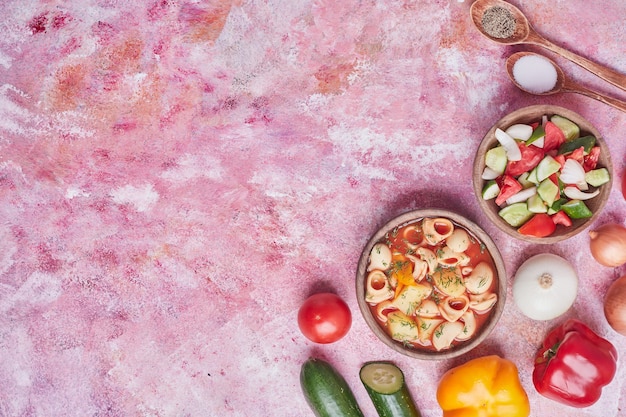 Free photo pasta soup in tomato sauce with vegetable salad.