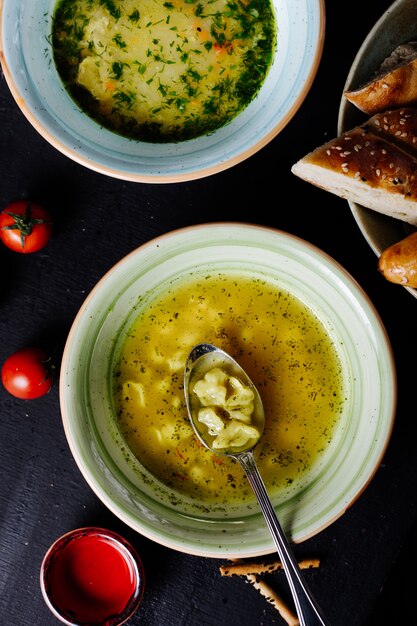 Макаронный суп с зеленью и ложкой внутри.