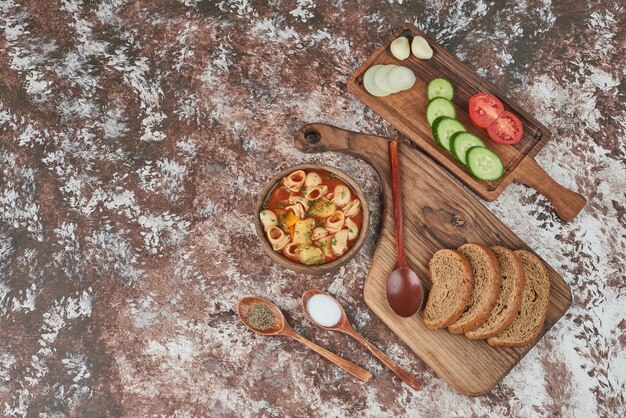 Pasta soup with a vegetable platter around.