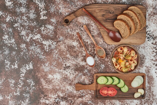 Pasta soup with vegetable salad and bread.