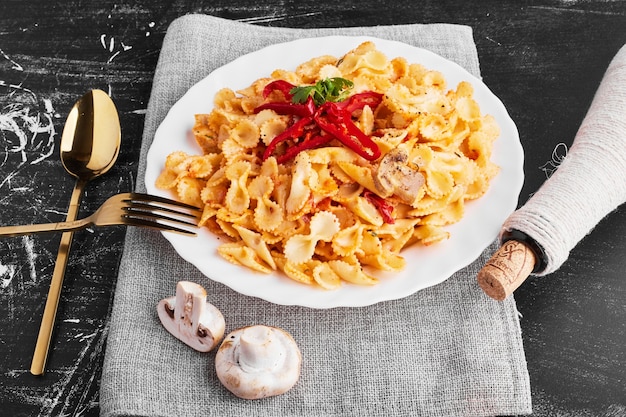 カトラリーを脇に置いた白いプレートのトマトソースのパスタ。